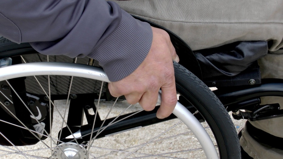 Close up view of hand on a wheelchair wheel.